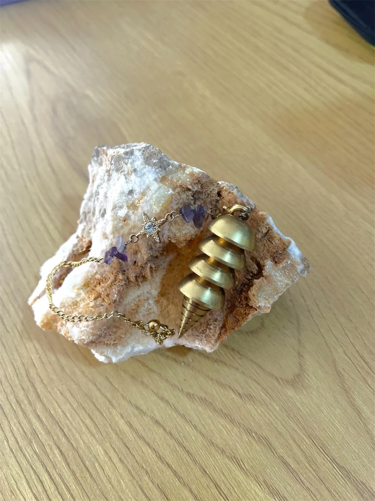 Un péndulo dorado de discos sobre una piedra de cuarzo